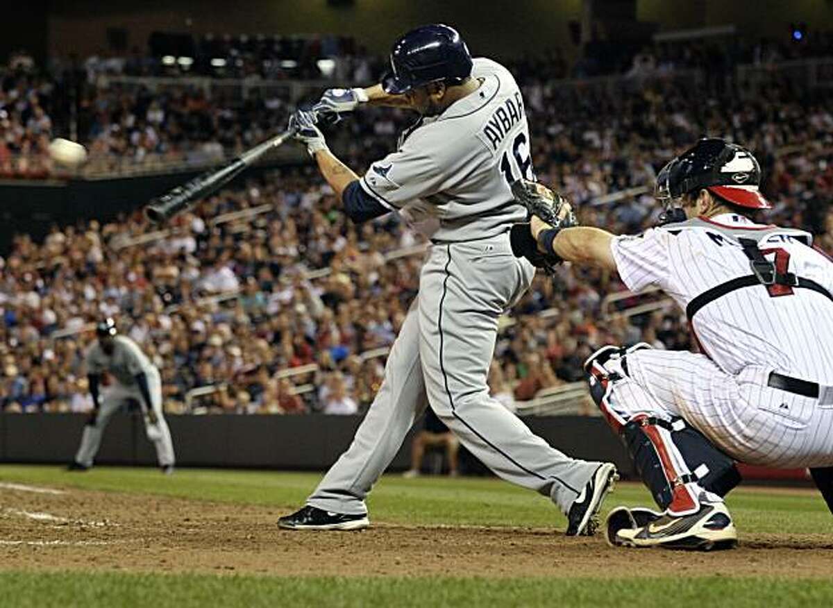 Tampa Bay Rays' Willy Aybar, left, hits an RBI single driving in the Rays' Reid Brignac on a pitch from the Minnesota Twins' Matt Guerrier during the tenth inning of a baseball game Thursday, July 1, 2010 in Minneapolis. Twins catcher Joe Mauer, right, watches. Tampa Bay won 5-4.