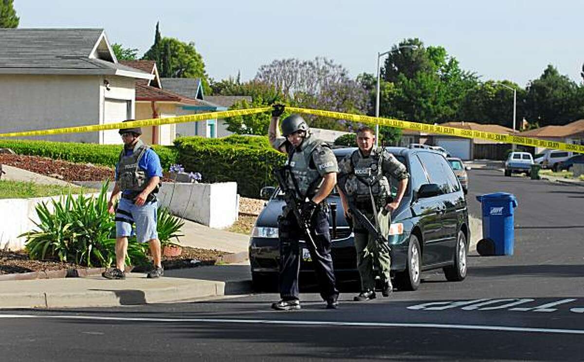 Antioch police officers walk through the neighborhood near the site of an early morning home invasion on Tuesday, June 8, 2010 in Antioch, Calif. A teenage suspect is dead and two victims were critically wounded. Antioch police said three teenage boys broke into the rear window of a one-story house where a marijuana growing operation was located around 4:30 a.m. (AP Photo/The Contra Costa Times, Susan Tripp Pollard) MAGS OUT; NO SALES; ARCHIVE OUT; TV OUT; MANDATORY CREDIT CONTRA COSTA TIMES
