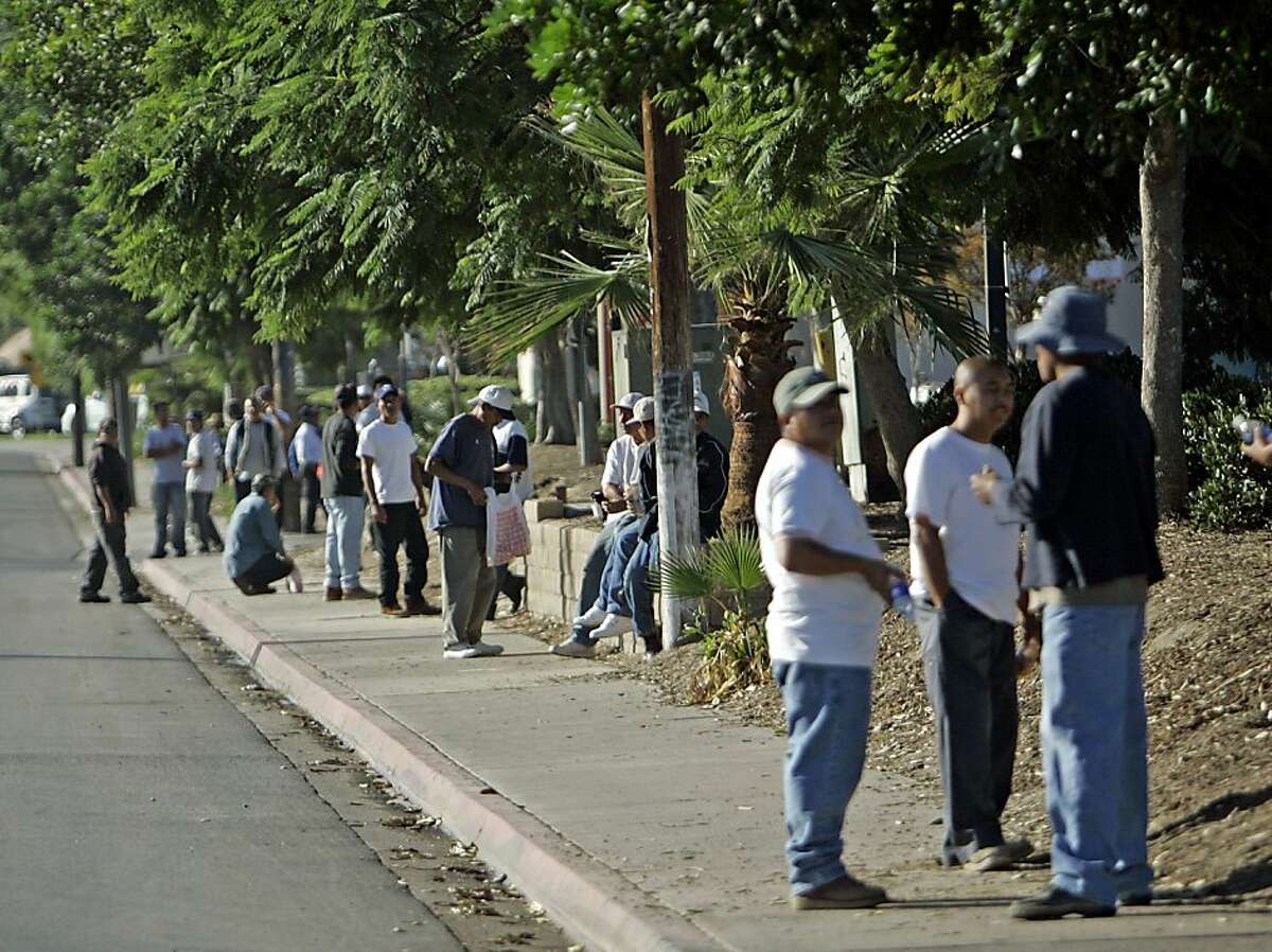 Day laborers crowd the sidewalk outside a Home Depot store hoping to catch a day job Thursday Oct. 23, 2008 in San Diego. Most of the those seeking work are migrants and many say they are considering heading back to their country of origin because of the slumping U.S. economy. (AP Photo/Lenny Ignelzi)