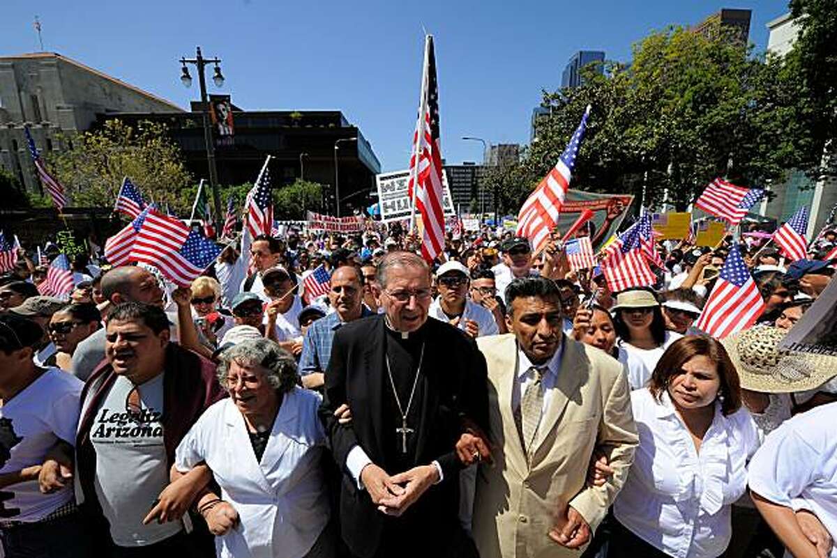 LOS ANGELES, CA - MAY 01: Los Angeles Cardinal Roger Mahony (C) joins thousands of demonstrators as they march during a May Day immigration rally on May 1, 2010 in Los Angeles, California. More than 100,000 people were expected to march from four directions towards Los Angeles City Hall to protest Arizona's new immigration law.