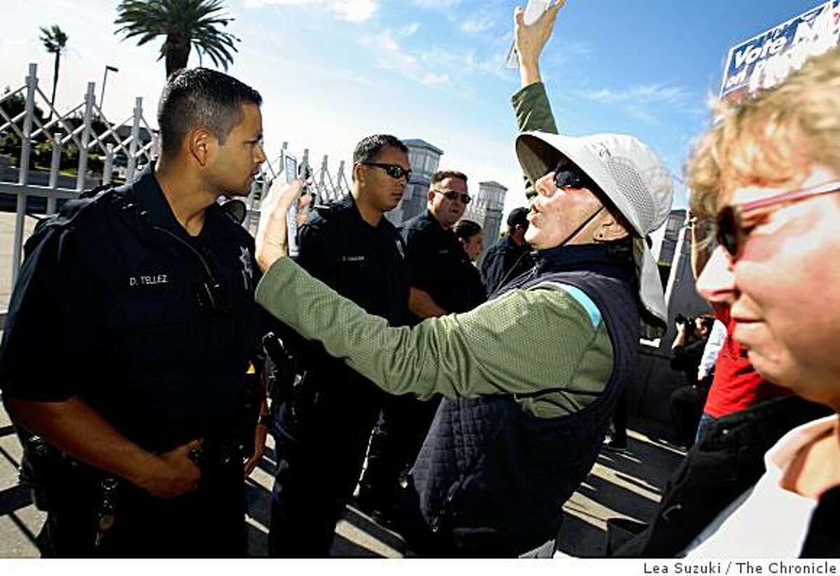 Viriginia Sorgi (with hat) of Oakland reads the Universal Declaration of Human Rights from cards as she stands with other protesters in front of a line of police officers at the Oakland Mormon Temple to protest the passage of Proposition 8 on Sunday, November 9, 2008 in Oakland, Calif.