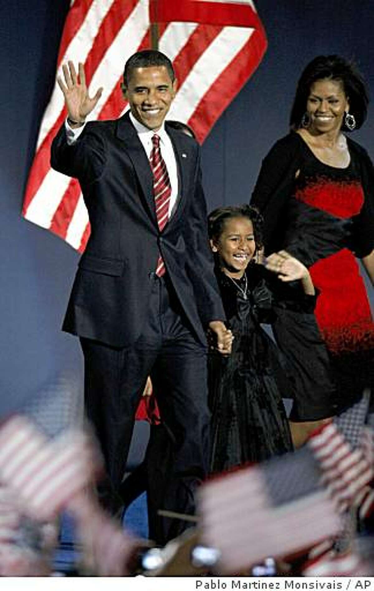 President-elect Barack Obama, his wife Michelle and daughter Sasha, 7, wave as they take the stage at his election night party at Grant Park in Chicago, Tuesday night, Nov. 4, 2008. (AP Photo/Pablo Martinez Monsivais)