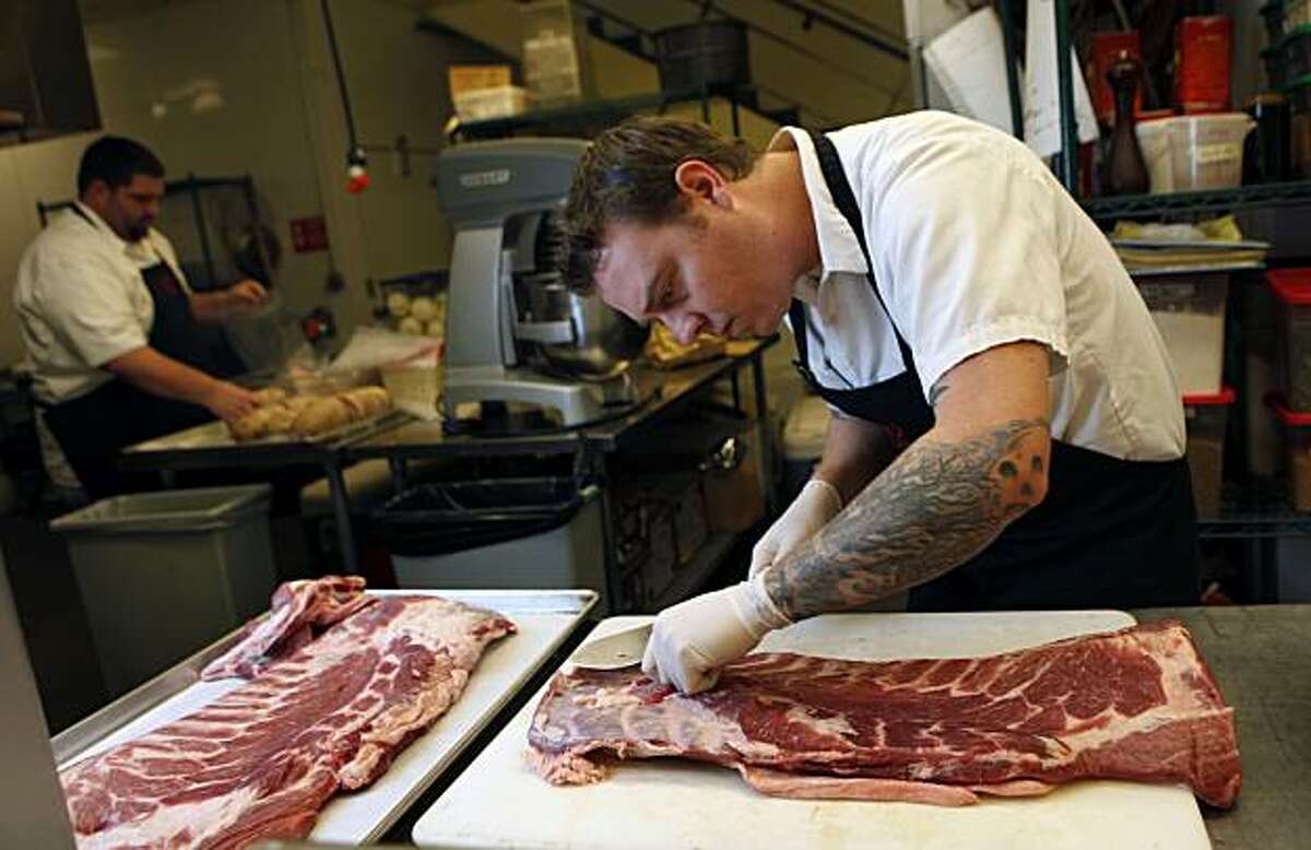 Taylor Boetticher owner-chef of Fatted Calf Charcuterie in Napa cuts up a boneless-skinless Pork Belly. The Fatted Calf is well-known for his cured bacon which is aged in a spiced down sugar based dry rub for one week before it's smoked and placed in the butcher shop display case. Friday Jan. 8, 2010