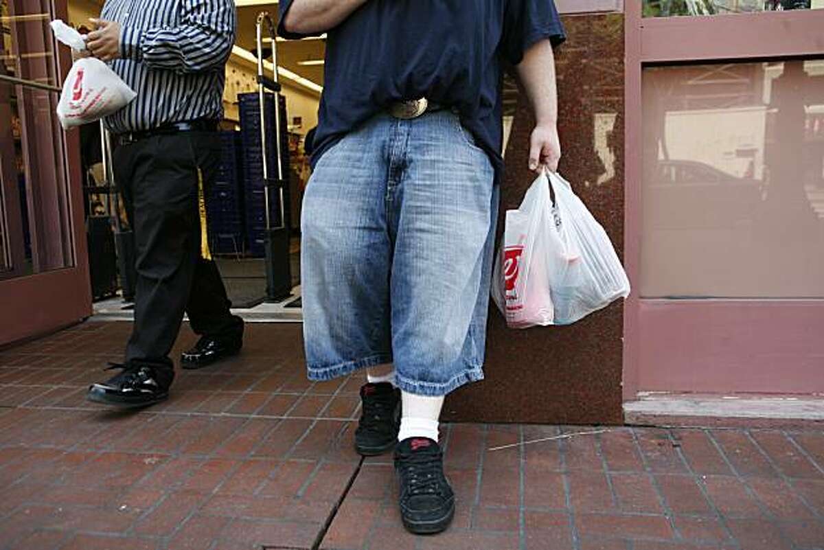 Luther Carr, (right) of San Francisco, holds newly purchased goods in a non-biodegradable plastic Walgreens bag front of the 850 Market Street store on Monday May 19, 2008 in San Francisco, Calif. On Monday some of the bags being used where non-recyclable while others were. The store is in the process of phasing out non-degradable plastic bags in preparation for the city-wide ban on them starting May 20, 2008. Photo by Mike Kepka / San Francisco Chronicle