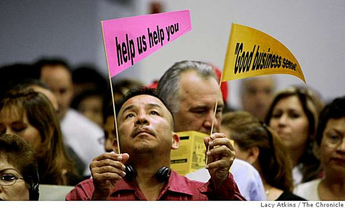 Juan Carlos reads the signs that were give to him along the the hundreds of people that gather for help and information concerning foreclosures, at the Holy Rosary Parish, Monday Oct. 27, 2008, in Antioch, Calif. He is looking at the possibility next month of foreclosure of his home in Antioch