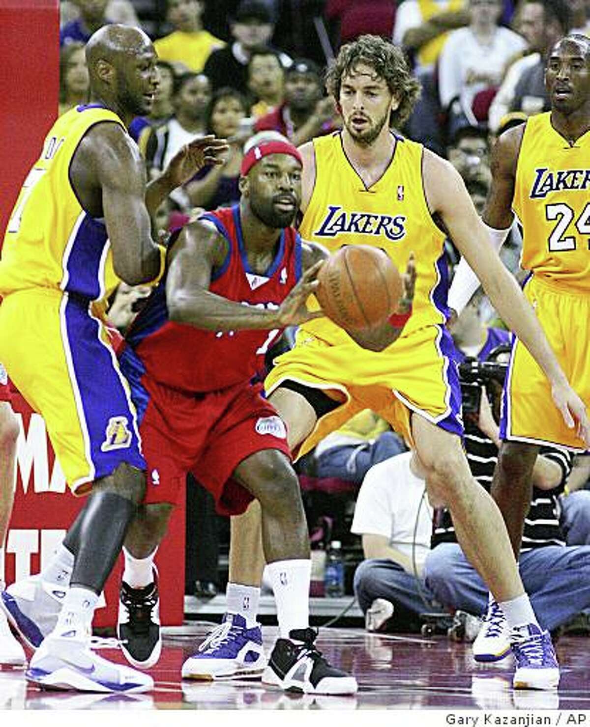 Los Angeles Clippers' Baron Davis, center, looks to pass between Los Angeles Lakers' Paul Gasol, right, of Spain, and Lamar Odom, left in the first half of a preseason game on Thursday, Oct. 9, 2008, in Fresno, Calif.