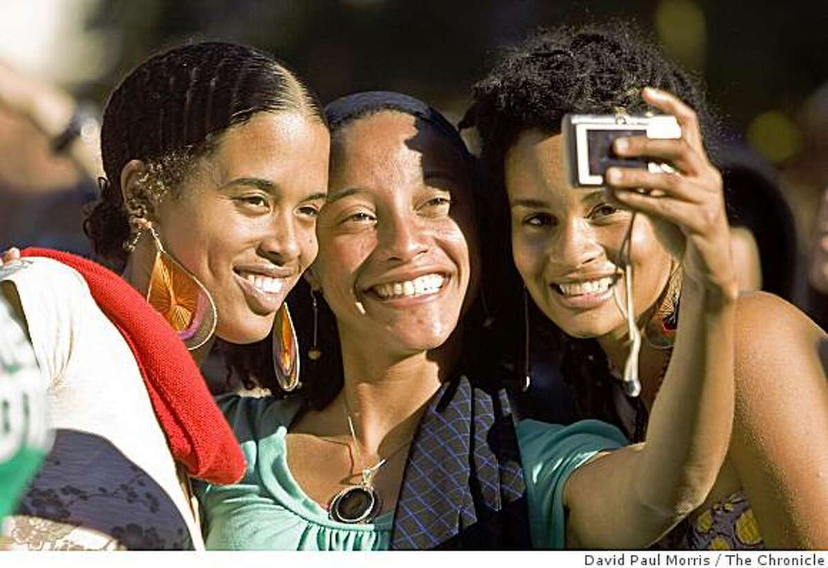 Selome Araya, LaToya Burton and Nikki Jones take their photo as the listen to Goapele sing at the newly dedicated Fillmore Center Plaza October 25, 2008 in San Francisco, California. Photograph by David Paul Morris / The Chronicle