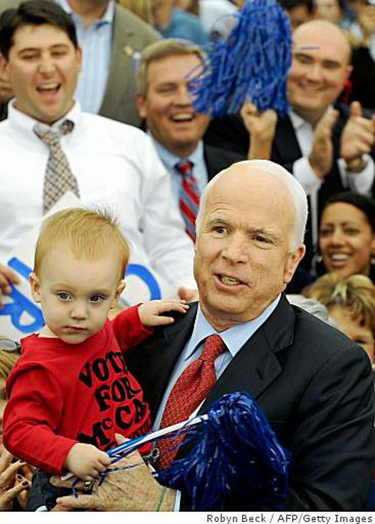 Republican presidential candidate John McCain holds a small child during a campaign rally at the Heartland High School & Academy in Belton, Missouri on October 20, 2008. AFP PHOTO Robyn BECK (Photo credit should read ROBYN BECK/AFP/Getty Images)