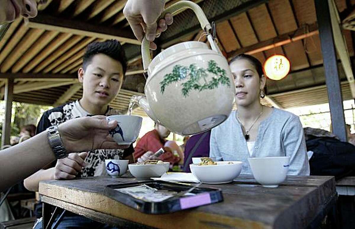 Hashim Aosafwani pours tea for Tony Vang (left) and Zahra Aosafwani during a visit to the Japanese Tea Garden at Golden Gate Park in San Francisco, Calif. on Wednesday Oct. 15, 2008.