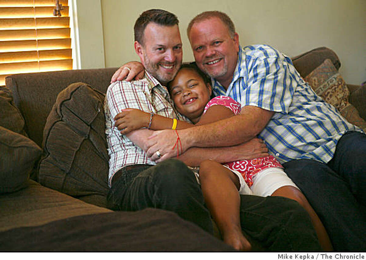 Together for 20 years, Gary Walker and Ed Valenzuela hug their daughter Kiki Valenzuela, 7, on their couch on Saturday Sept. 6, 2008 in Berkeley, Calif.