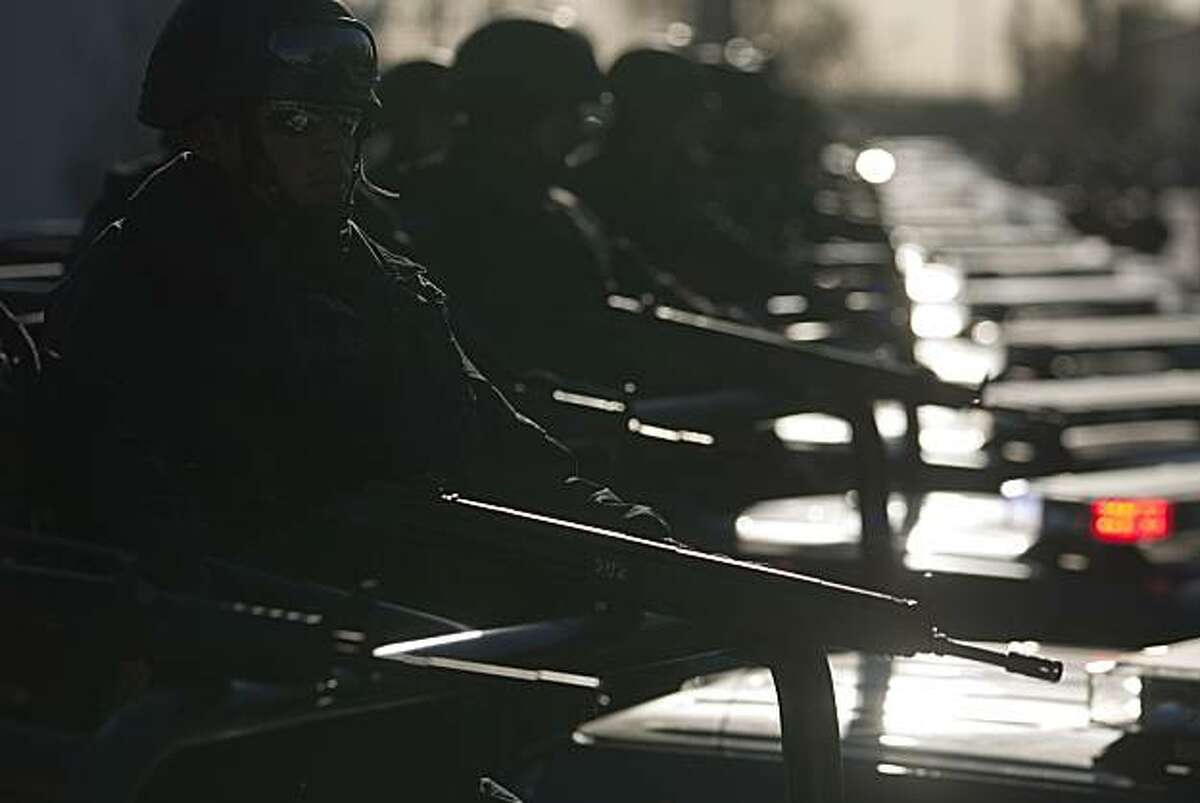 Federal police stand in formation on the back of trucks as they begin their patrols in Ciudad Juarez, Mexico, Thursday, April 8, 2010. The federal police are taking the lead of the city's security which was headed by the army in recent months.