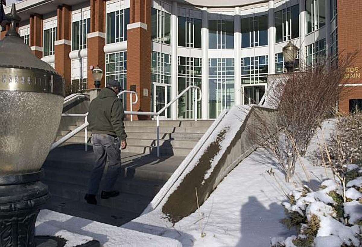 In this March 10, 2010 photo, building contractor Denl Thomas walks up the stairs at the Klamath County administration building in Klamath Falls, Ore., where sidewalks heated by geothermal energy keep snow from piling up. With a brew pub, college campus and commercial greenhouses all warmed by heat from deep within the earth, Klamath Falls serves as a model for a fledgling new green energy source that is gaining steam with the help of $338 million in federal stimulus money.