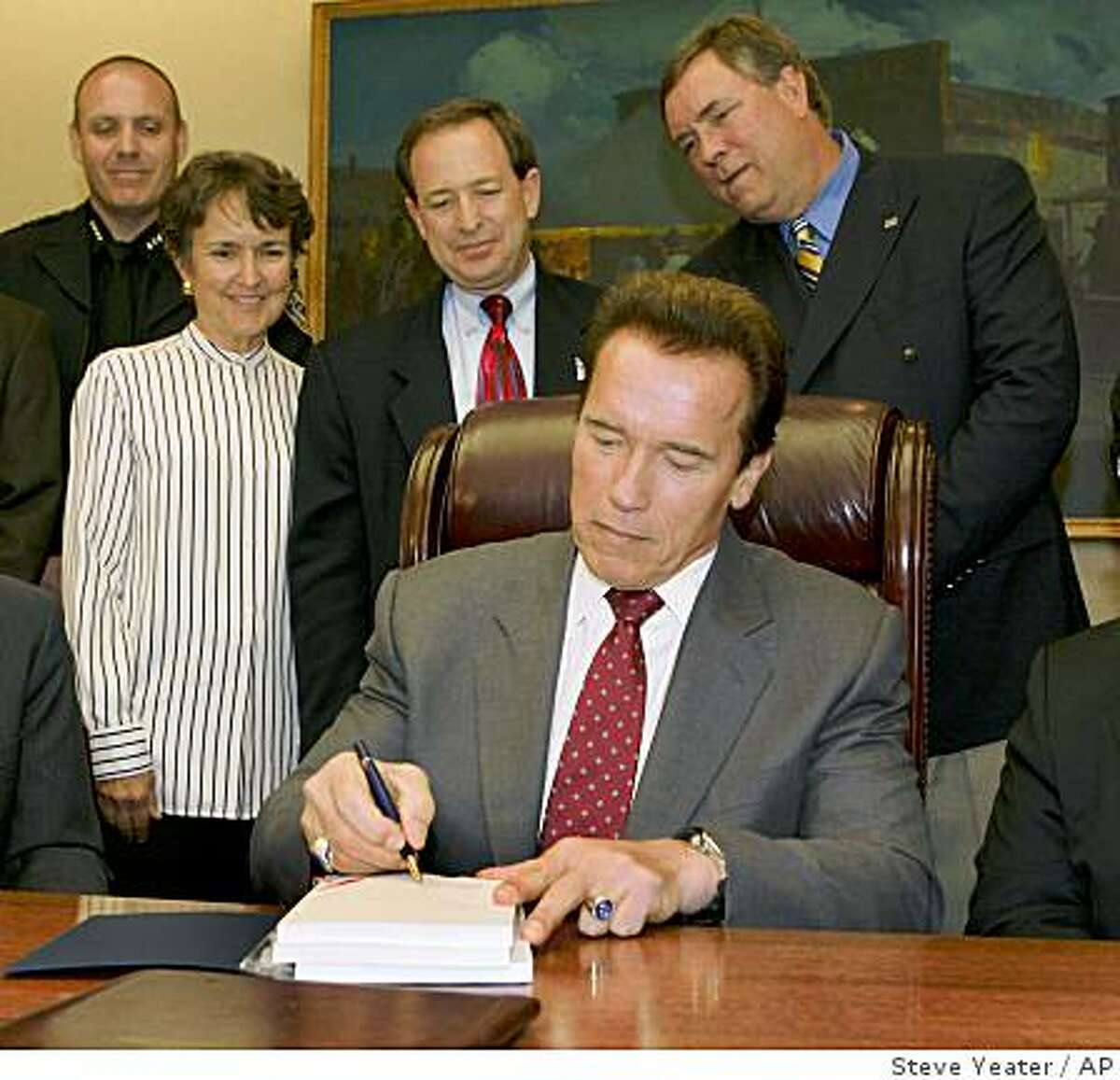 California Gov. Arnold Schwarzenegger signs the 2008-2009 state budget as representatives from local governments look on during a small ceremony in his office at the Capitol in Sacramento, Calif., on Tuesday, Sept. 23, 2008.(AP Photo/Steve Yeater)