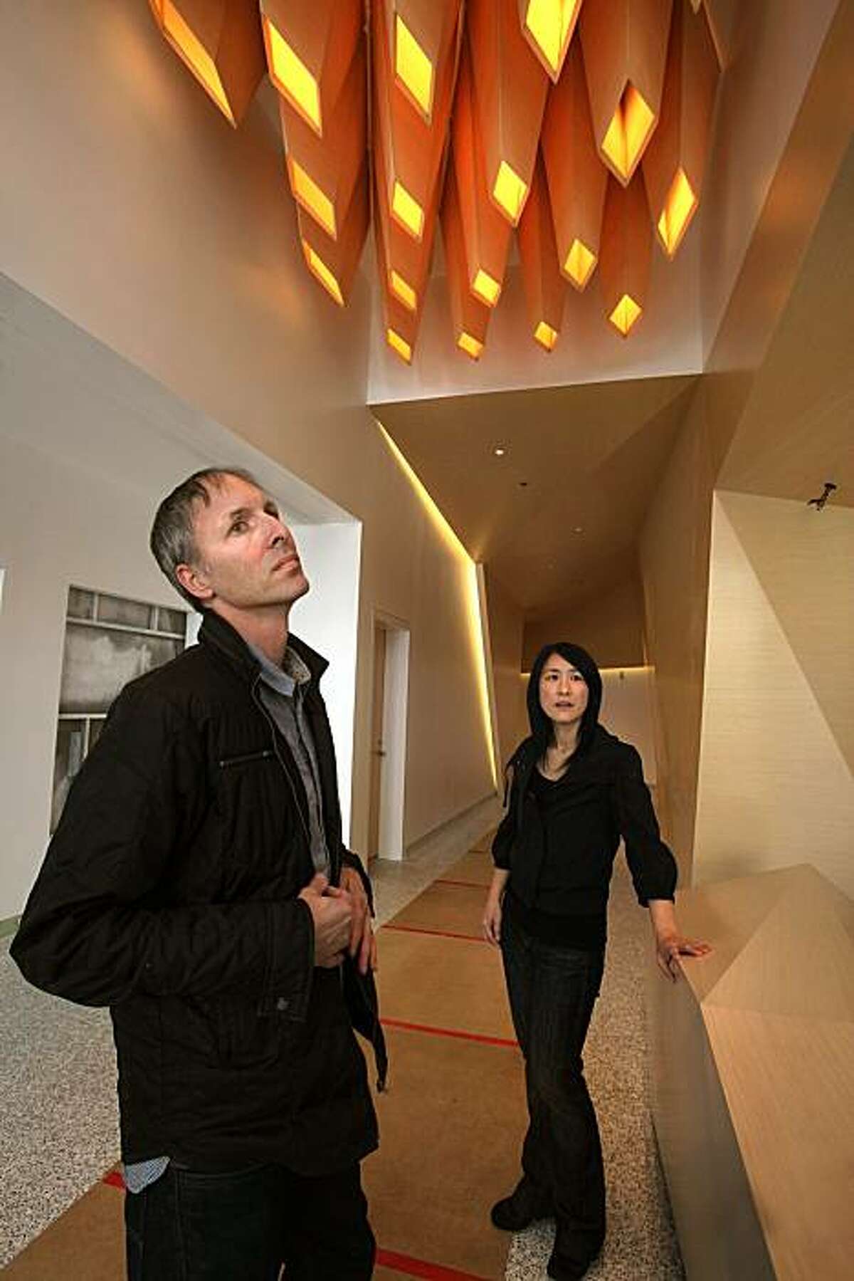 Architects Craig Scott and Lisa Iwamoto have handmade coffered overhead lighting, a custom made desk, and custom made walls with recess lighting in the lobby of their first downtown San Francisco project in progress at One Kearny on Tuesday, March 23, 2010.