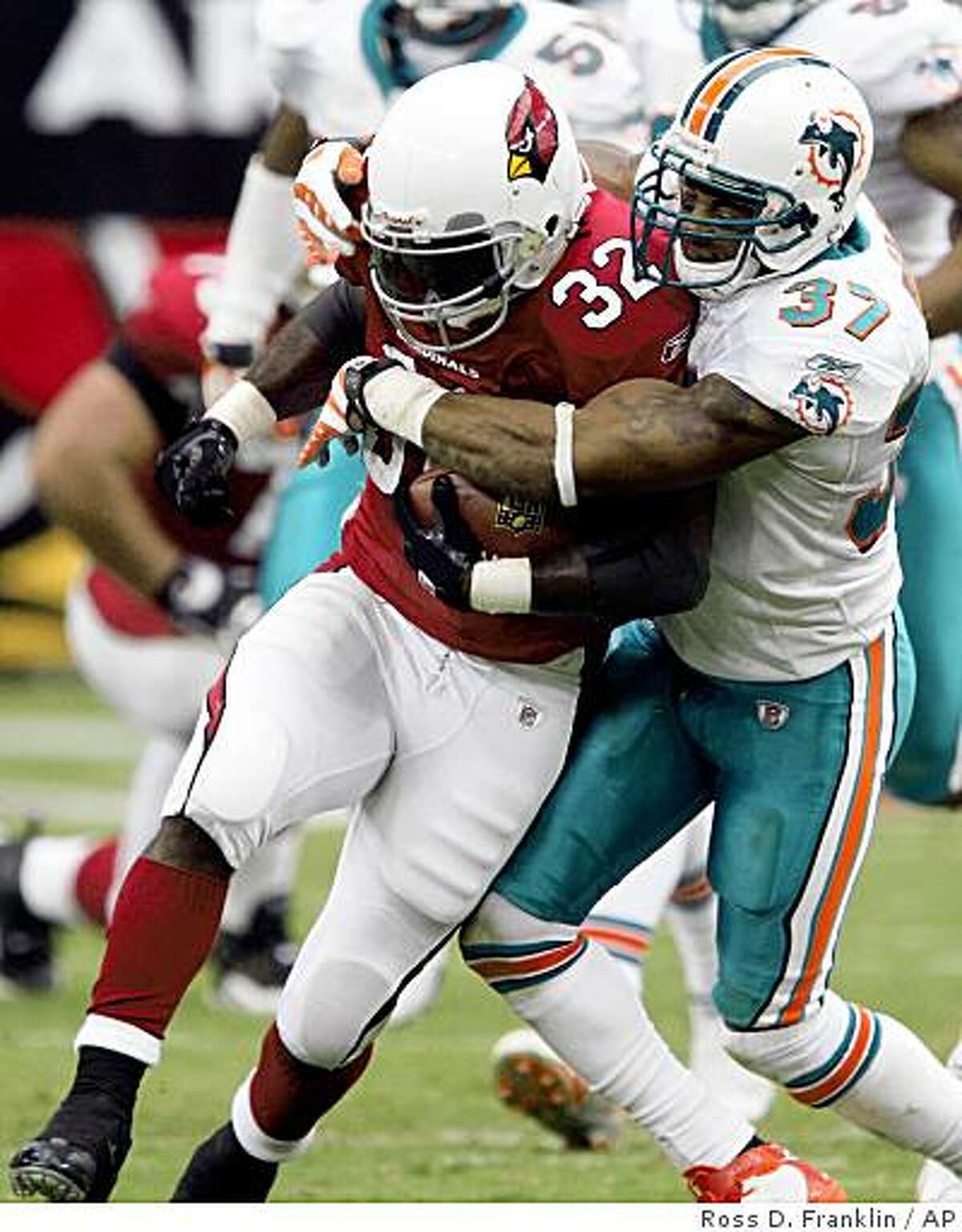 Miami Dolphins' Yeremiah Bell (37) tackles Arizona Cardinals' Edgerrin James (32) in the first quarter of a football game Sunday, Sept. 14, 2008, in Glendale, Ariz. The Cardinals defeated the Dolphins 31-10. (AP Photo/Ross D. Franklin)