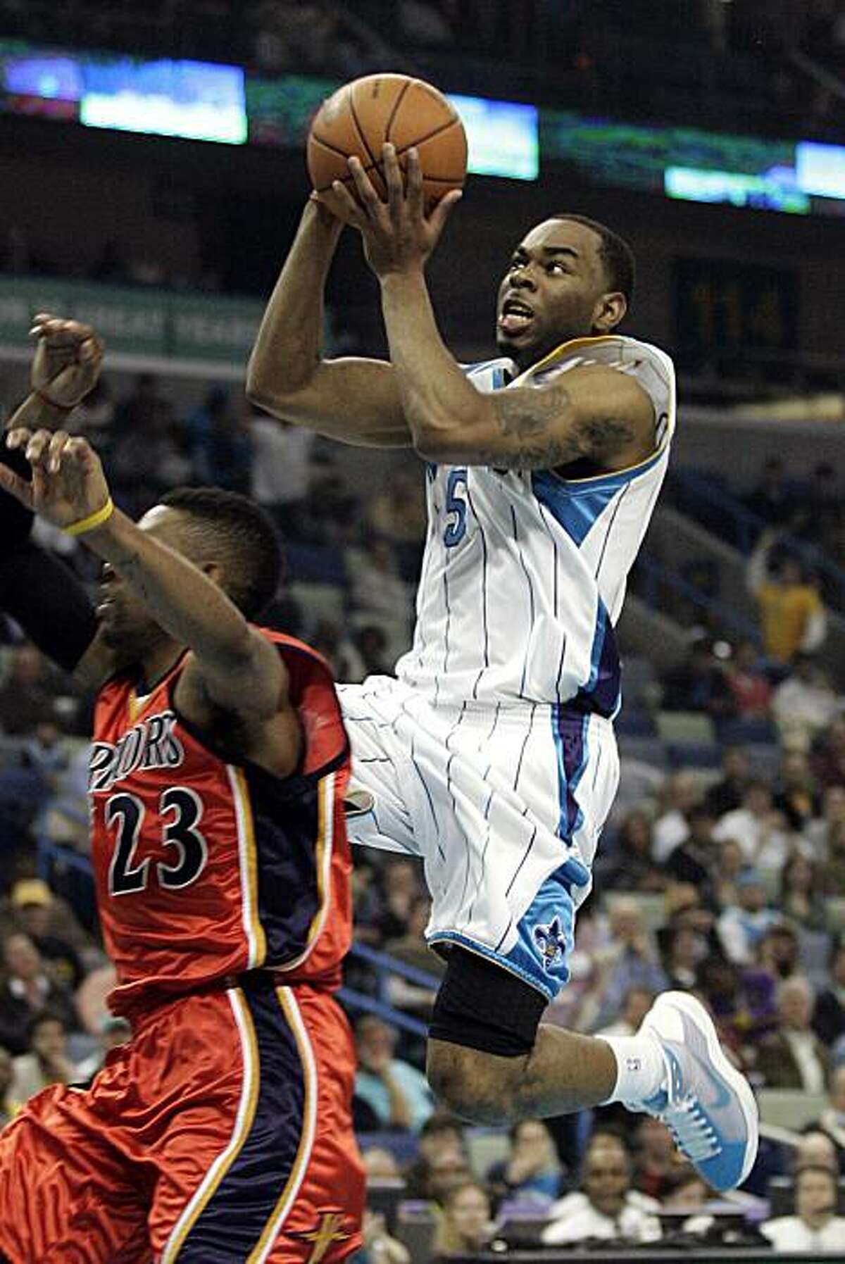 New Orleans Hornets guard Marcus Thornton (5) goes up for a shot over Golden State Warriors guard C.J. Watson (23) during the first half of an NBA basketball game in New Orleans, Monday, March 8, 2010.