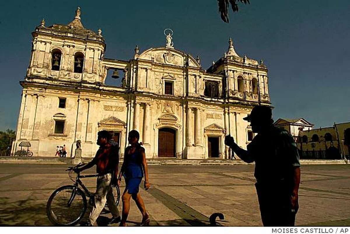Tourists walk in front of the Cathedral of the Asuncion in Leon, 90km north of Managua, Nicaragua, in this Feb. 7, 2005 file photo. Attracted by it's exhuberant nature, indigenous cultutres and vestiges of a colonial past, more and more tourists are now visiting Central America.