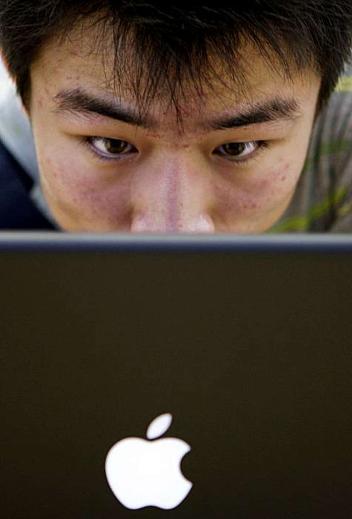 ** FILE ** In this July 19, 2008 file photo, a customer looks at a computer in Beijing's newly-opened Apple computer store. Customers in China of Apple Inc.'s iTunes online music store were unable to download songs since Monday, Aug. 18, 2008 and an activist group said Beijing was trying to block access to a new Tibet-themed album. (AP Photo/Oded Balilty, File)