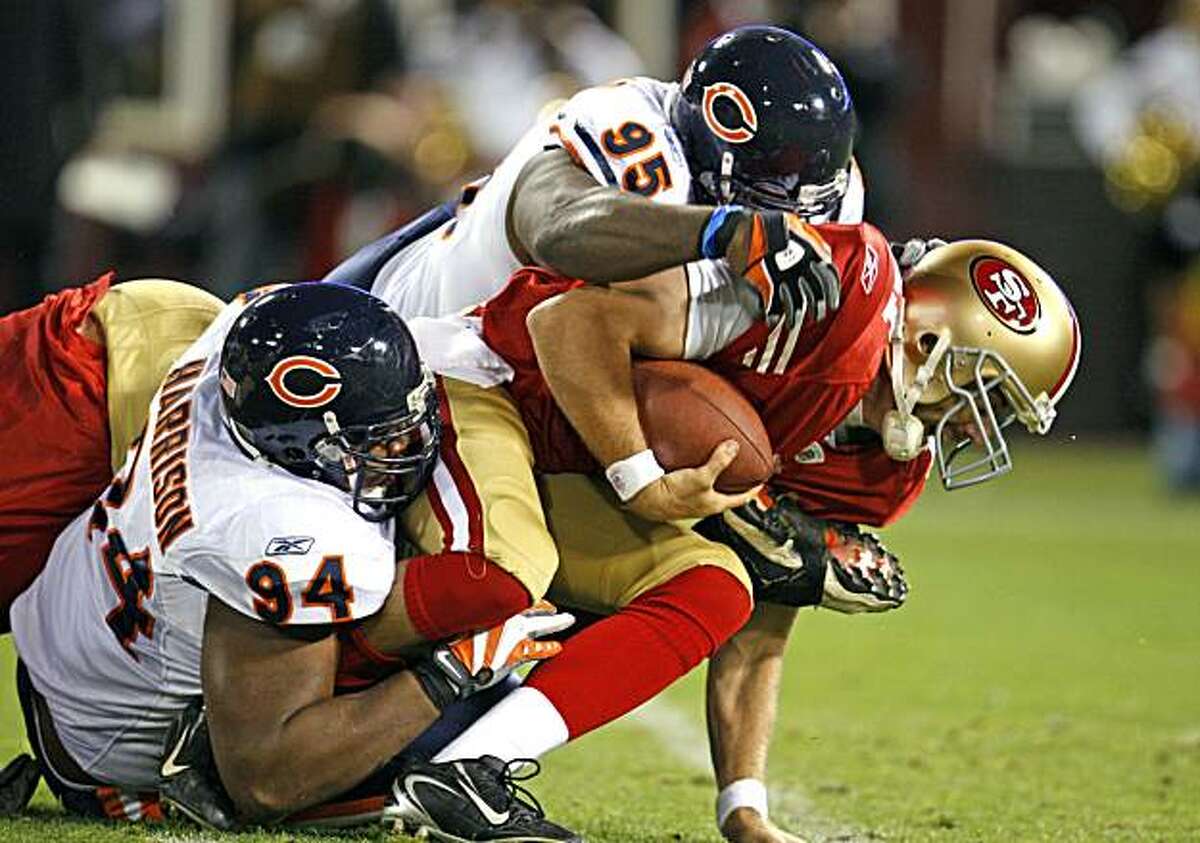 San Francisco 49ers Quarterback Alex Smith is sacked in the 2nd quarter by Chicago Bears Marcus Harrison 94 and Anthony Adams 95 at Candlestick Park Thursday November 12, 2009. San Francisco 49ers lead the Chicago Bears 7-3 at the half.