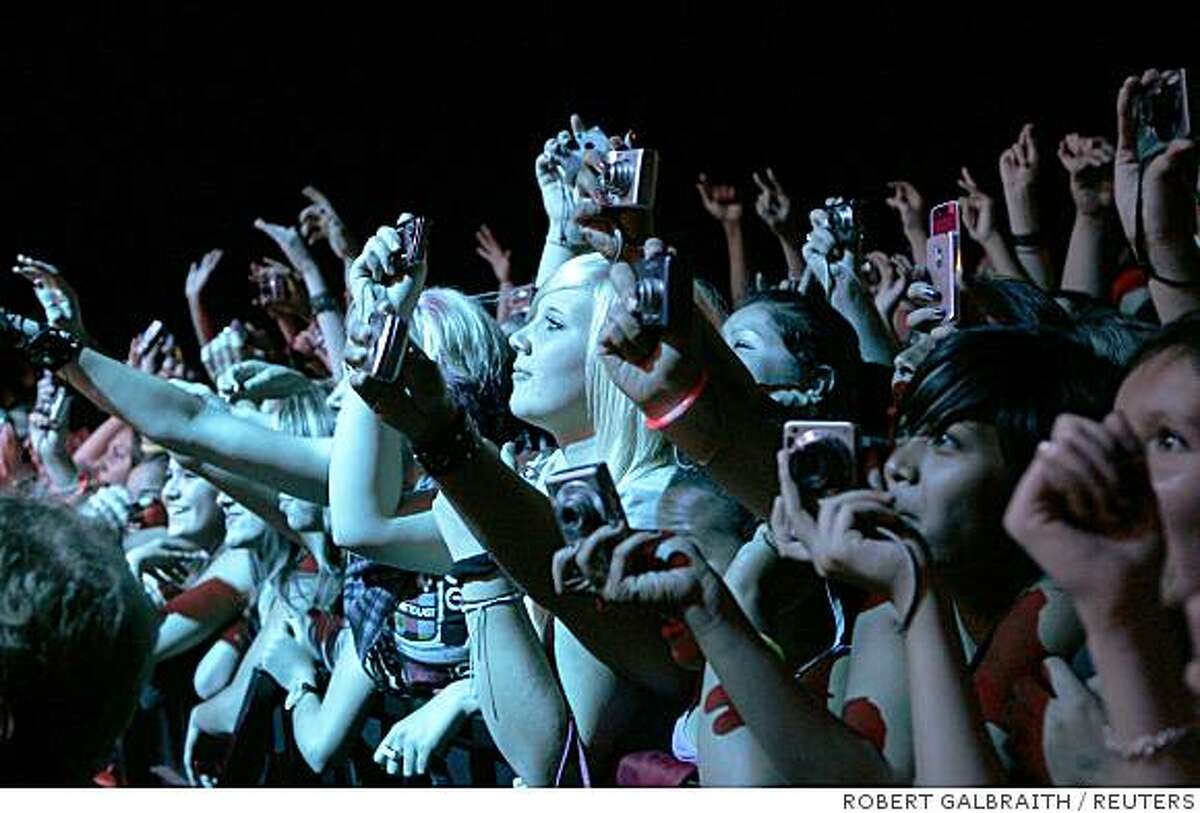 Fans take photographs during a performance by the band "Tokio Hotel" at The Fillmore in San Francisco, California August 19, 2008.