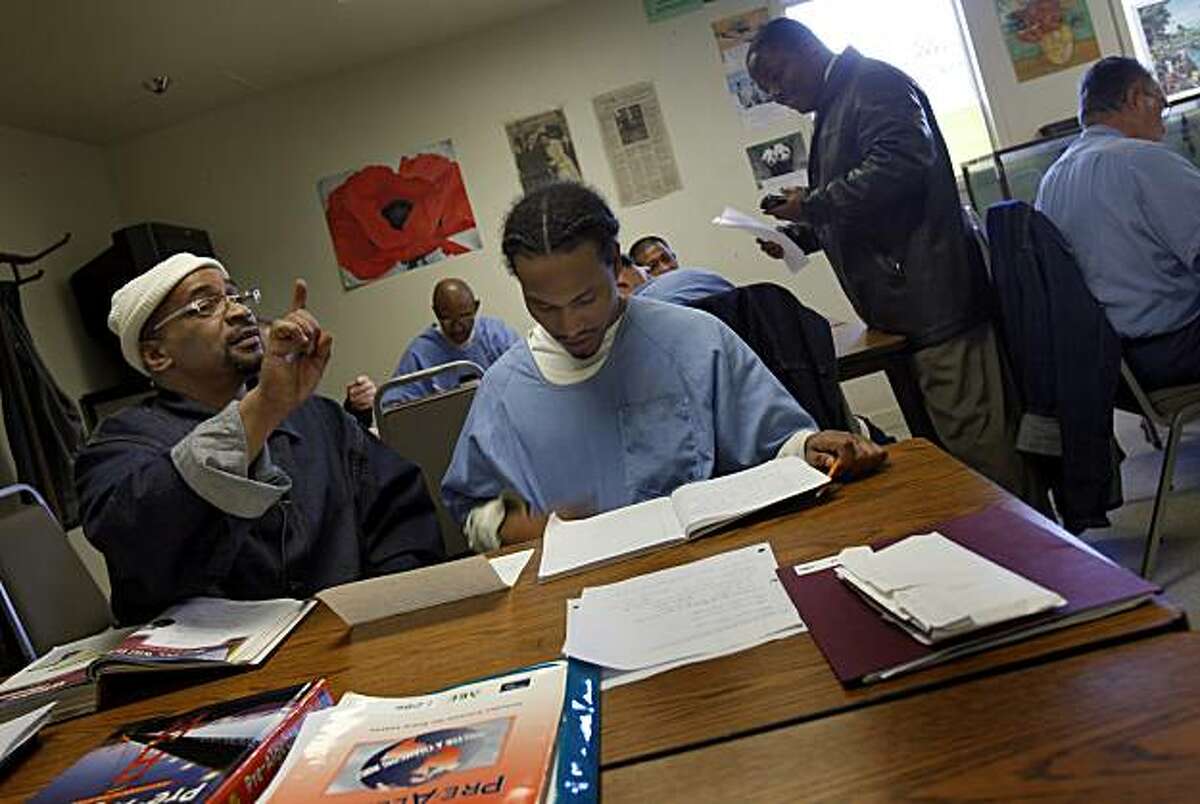 Inmate Derrick Cooper (left) posed a question while he and Dominique Oden did papers in their adult basic education class Tuesday February 9, 2010, one of the educational opportunities at the prison. A new California law aimed at cutting prison spending includes the cutting of education and vocational spending at San Quentin (Marin County) and other state prisons.