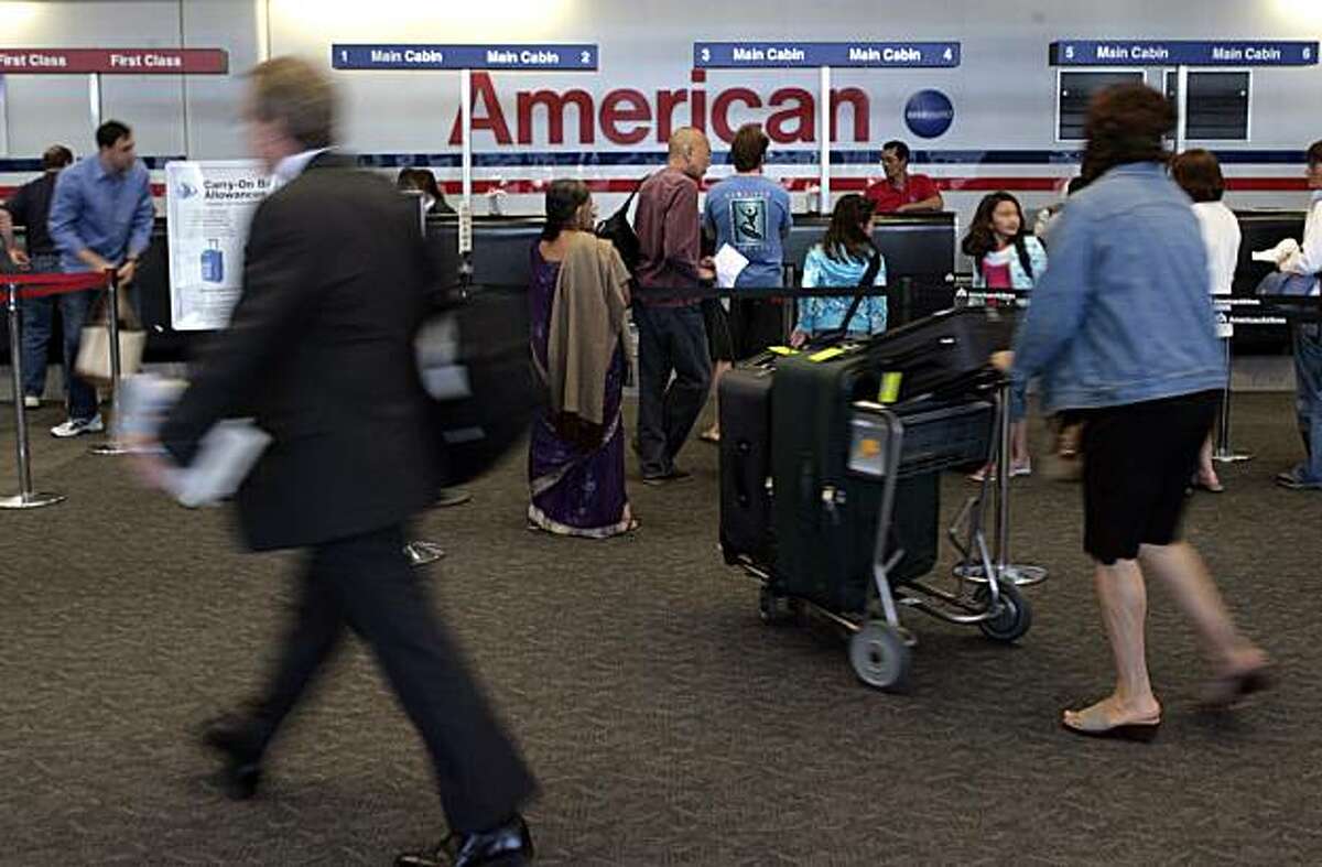 Passengers walk near the American AIrlines ticketing area at San Francisco International Airport on Wednesday, May 21, 2008 as American announced it would begin charging $15 for passengers' first checked bag beginning on June 15, 2008. Photo by Kim Komenich / San Francisco Chronicle