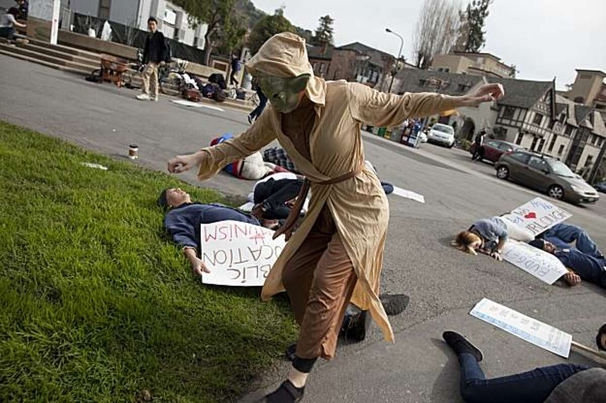 Kelly Rafferty plays yoda as she marches over members of the satirical protest group UCMeP, UC Movement of Efficient Privatization as they film an instructional video on how to have a protest on the UC Berkeley campus on Thursday February 11, 2010 in Berkeley, Calif. Photograph by David Paul Morris / Special to the Chronicle