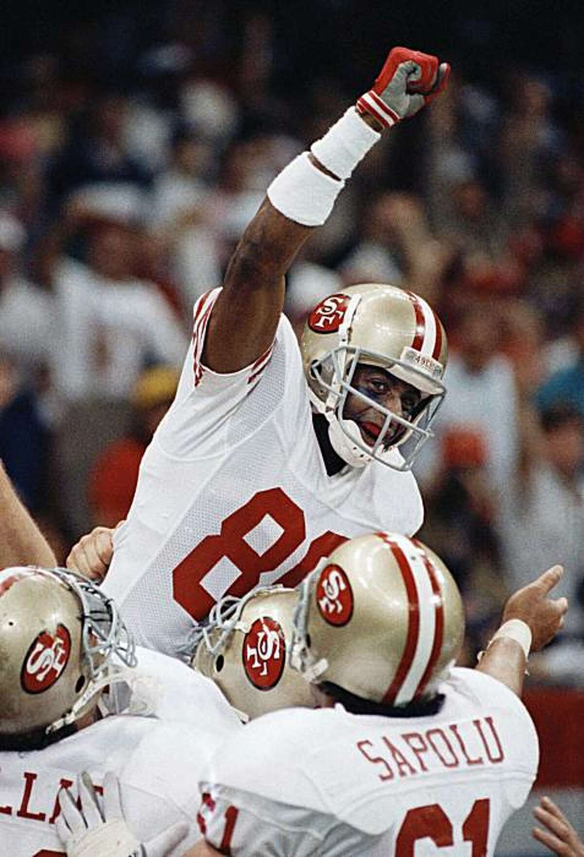 FILE - In this Jan. 28, 1990 file photo, San Francisco 49ers wide receiver Jerry Rice raises his fist in jubilation after scoring his second touchdown of the day with 34 seconds left in the second quarter against the Denver Broncos in New Orleans at SuperBowl XXIV. Rice caught more passes and scored more touchdowns than anyone else. Emmitt Smith ran for more yards than any other NFL player. Sure seems appropriate for them to enter the Pro Football Hall of Fame together, and it figures to happen Saturday,Feb. 6, 2010.