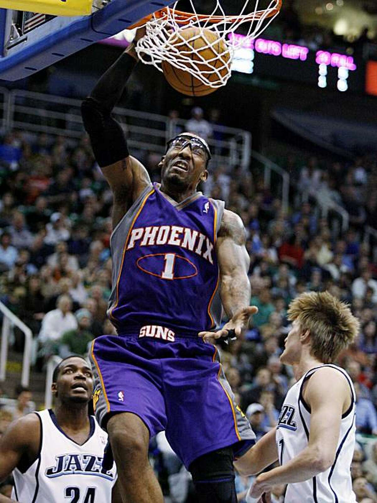 Phoenix Suns forward Amare Stoudemire (1) dunks as Utah Jazz's Paul Millsap (24) and Andrei Kirilenko (47), of Russia, look on during the first half of an NBA basketball game Monday, Jan. 25, 2010, in Salt Lake City.