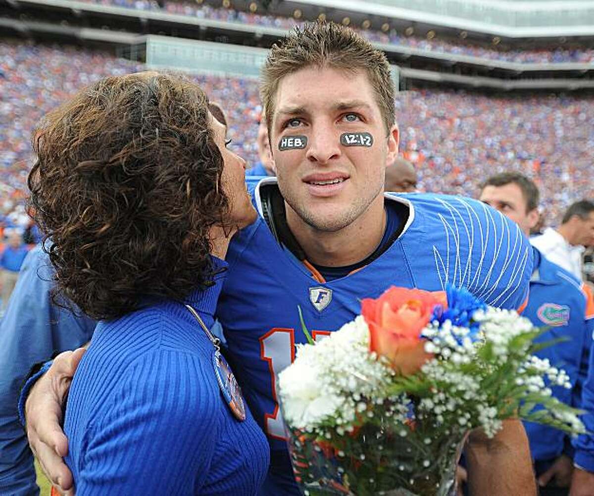 FILE - In this Nov. 28, 2009, file photo, Florida quarterback Tim Tebow embraces his mother, Pam, during a pre-game ceremony for graduating seniors on the Florida football team prior to an NCAA college football game against Florida State in Gainesville, Fla. CBS responded to complaints over a conservative group's planned Super Bowl ad featuring football star Tim Tebow and his mother Pam by saying that it had eased restrictions on advocacy ads and would consider "responsibly produced" ones for open spots in its Feb. 7 broadcast. CBS said Tuesday, Jan. 26, 1010, it had received numerous e-mails _ both critical and supportive _ since a coalition of women's groups began a protest campaign Monday against the ad, which the critics say will use Tebow and hi