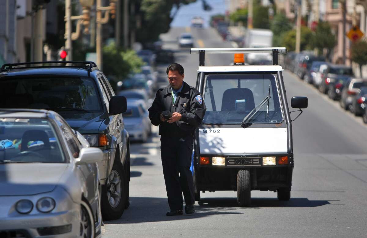 Many San Francisco residents would agree that North Beach is one of the city's most difficult neighborhoods for parking. In this image, parking control officer Joe Raquiza checks cars parking in the North Beach area, Thursday July 31, 2008, in San Francisco, Calif. 