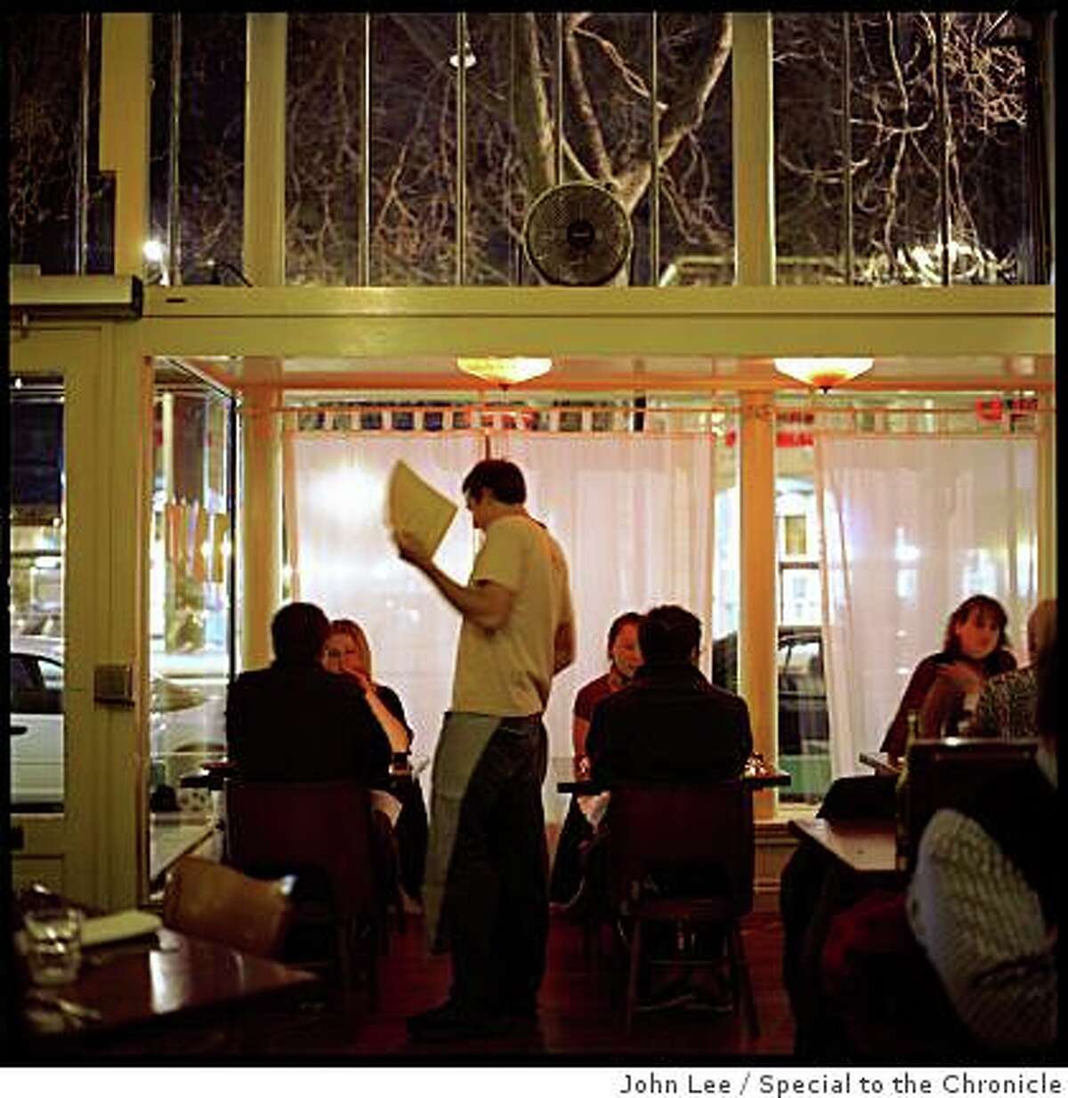A server waits on diners in the main dining room of Pizzaiolo in Oakland.