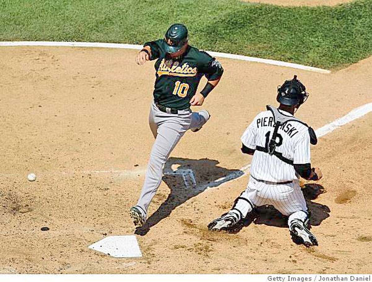 CHICAGO - JULY 06: Daric Barton #10 of the Oakland Athletics scores a run in the 7th inning as the ball gets away from A.J. Pierzynski #12 of the Chicago White Sox on July 6, 2008 at U.S. Cellular Field in Chicago, Illinois. The White Sox defeated the Athletics 4-3. (Photo by Jonathan Daniel/Getty Images)