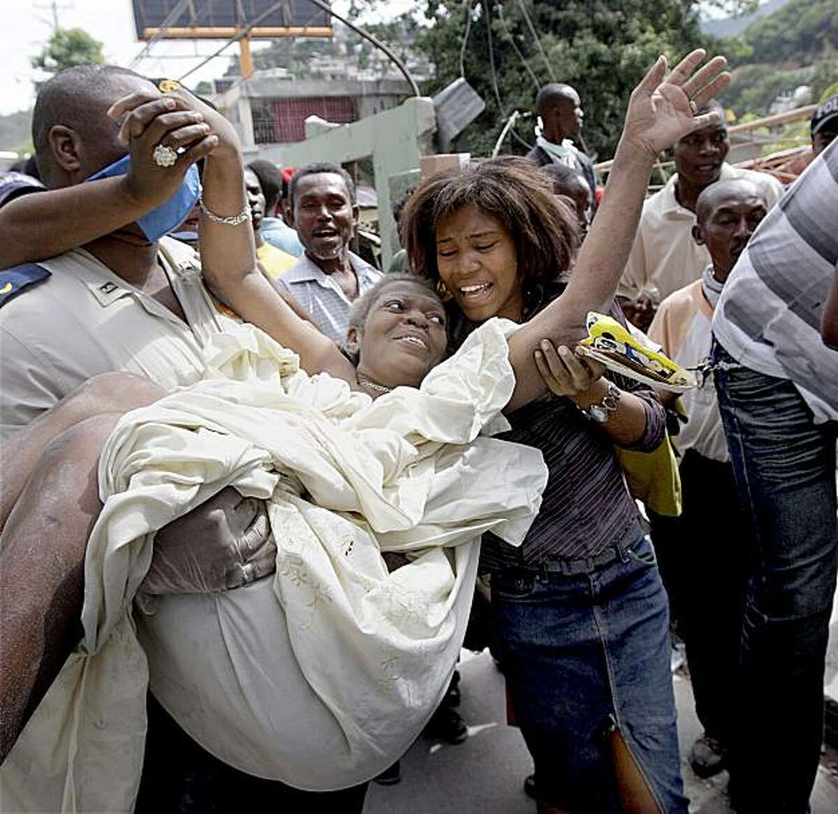 ** CORRECTS TO MIDDLE NAME TO LOUIS **Gladys Louis Jeune is pulled alive from the rubble of her home in Port-au-Prince nearly 43 hours after Tuesday's earthquake, where she was greeted by her ecstatic daughter Thursday, Jan. 14, 2010. (AP Photo/The Miami Herald, Patrick Farrell) NO MAGS; NO SALES; TV OUT