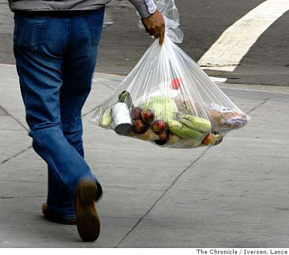 A visitors to San Francisco's Ingleside Community Center Pantry walks away with a bag of food after he and other sorted through their food, exchanging items outside the exit door of the food bank on Ocean Ave. Photographed in San Francisco Thursday July 3, 2008 By Lance Iversen / The Chronicle
