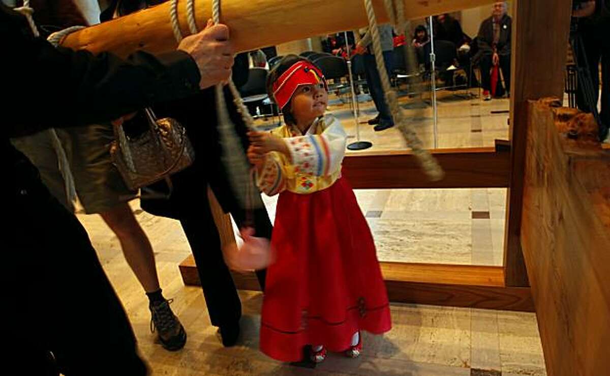 Claire Austin, 4 years old, gives a big swing as she rings the 2100 pound sixteenth-century Japanese bell at the 24th Annual Japanese New Year's Bell-Ringing Ceremony, Thursday Dec. 31, 2009, at the Asian Art Museum in San Francisco, Calif. Austin is dressed in traditional Korean wear.