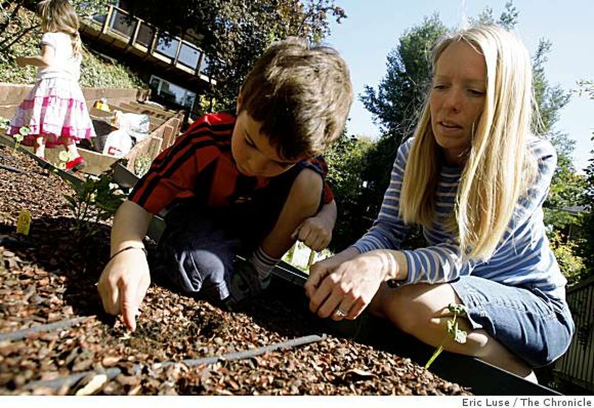 Elizabeth Singh plants seeds with her son Arjun,6, with Soraya,3, in the background in the family garden at their home photographed in San Anselmo on Monday, May 11, 2009.