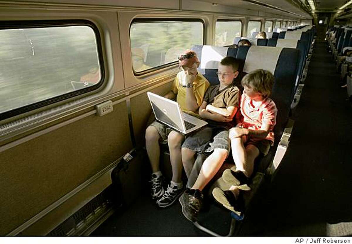 **ADVANCE FOR WEEKEND EDITIONS, SEPT. 8-9** Justin Braun, 12. left, Dylan White, 10, center, and younger brother Riley White, 8, use a computer as they travel toward Chicago, Monday, July 9, 2007, on Amtrak's Lincoln Service between St. Louis and Chicago. (AP Photo/Jeff Roberson)