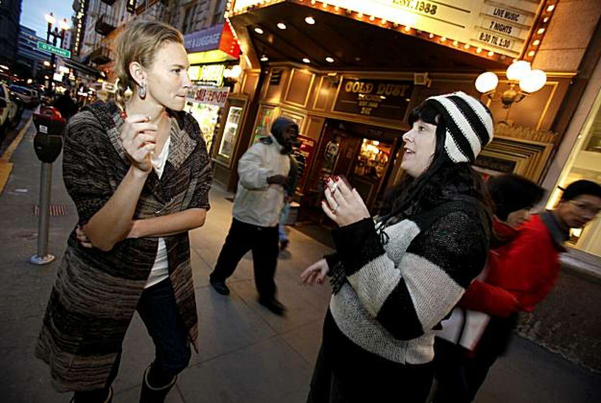 Megan Gomes (left) and Shannon Friend stood on a busy Powell Street near Union Square for a cigarette break in between shopping for Christmas presents.