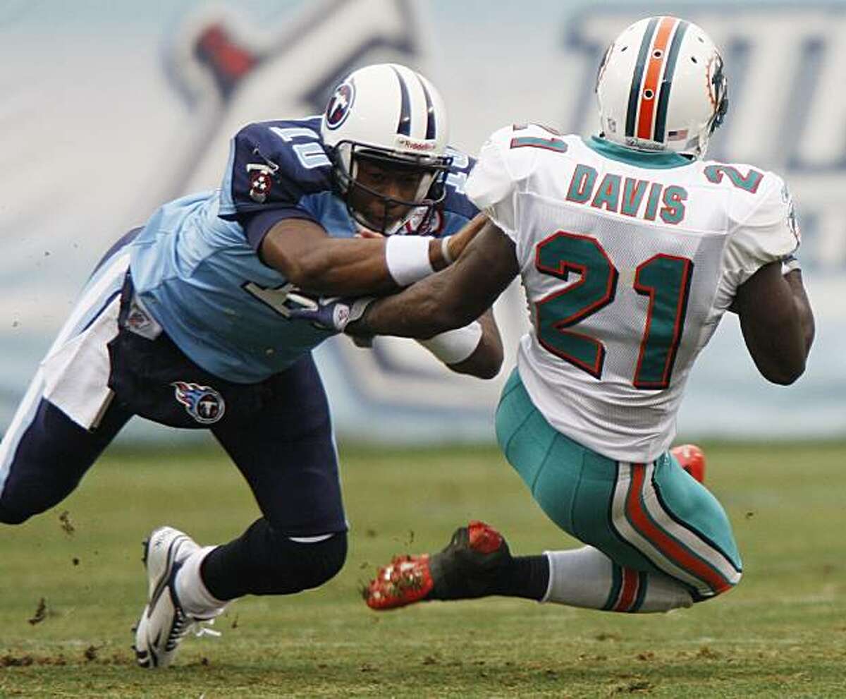 Tennessee Titans quarterback Vince Young (10) tackles Miami Dolphins cornerback Vontae Davis (21) after Davis intercepted a pass by Young and returned the ball 26 yards in the first quarter of an NFL football game on Sunday, Dec. 20, 2009, in Nashville, Tenn. (AP Photo/Wade Payne)