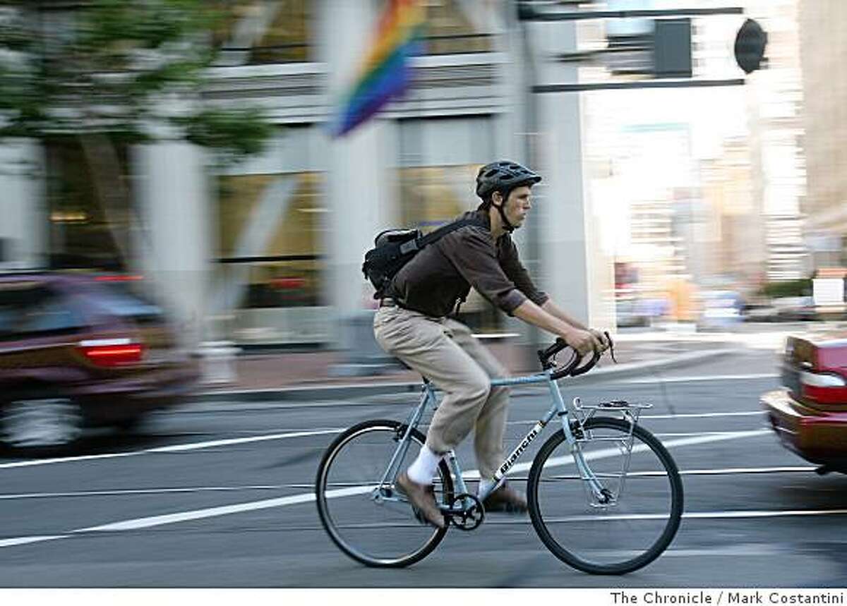 A man in slacks rides his bike on Market St. in San Francisco, Calif. on Tuesday, June 25, 2008. Photo by Mark Costantini / The Chronicle.