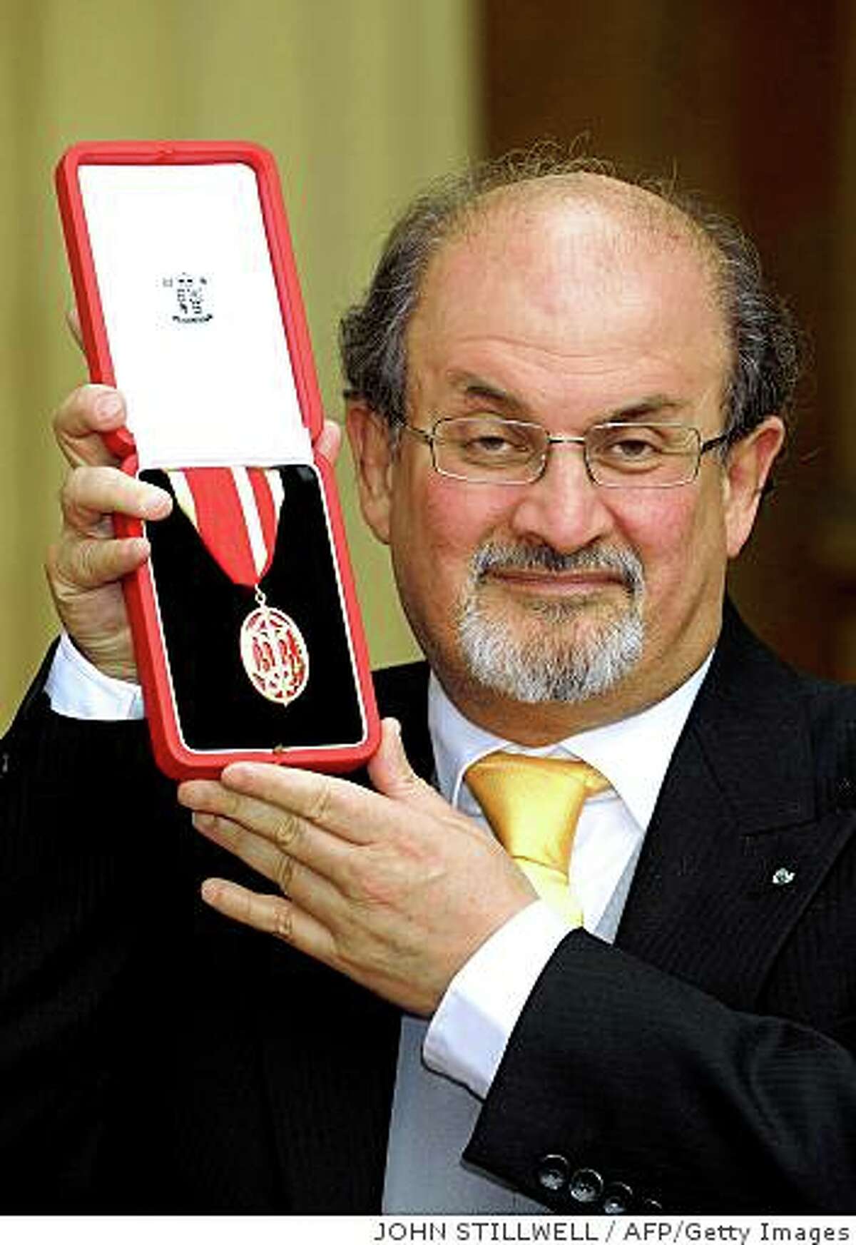 British author Sir Salman Rushdie poses for photographs after receiving his knighthood from Britain's Queen Elizabeth II at Buckingham Palace, in London, on June 25, 2008. Queen Elizabeth II on Wednesday gave the British author Salman Rushdie his controversial knighthood, which caused protests by Muslims around the world when it was announced last year. Rushdie, 61, was knighted for his services to literature. AFP PHOTO/John Stillwell/POOL (Photo credit should read JOHN STILLWELL/AFP/Getty Images)