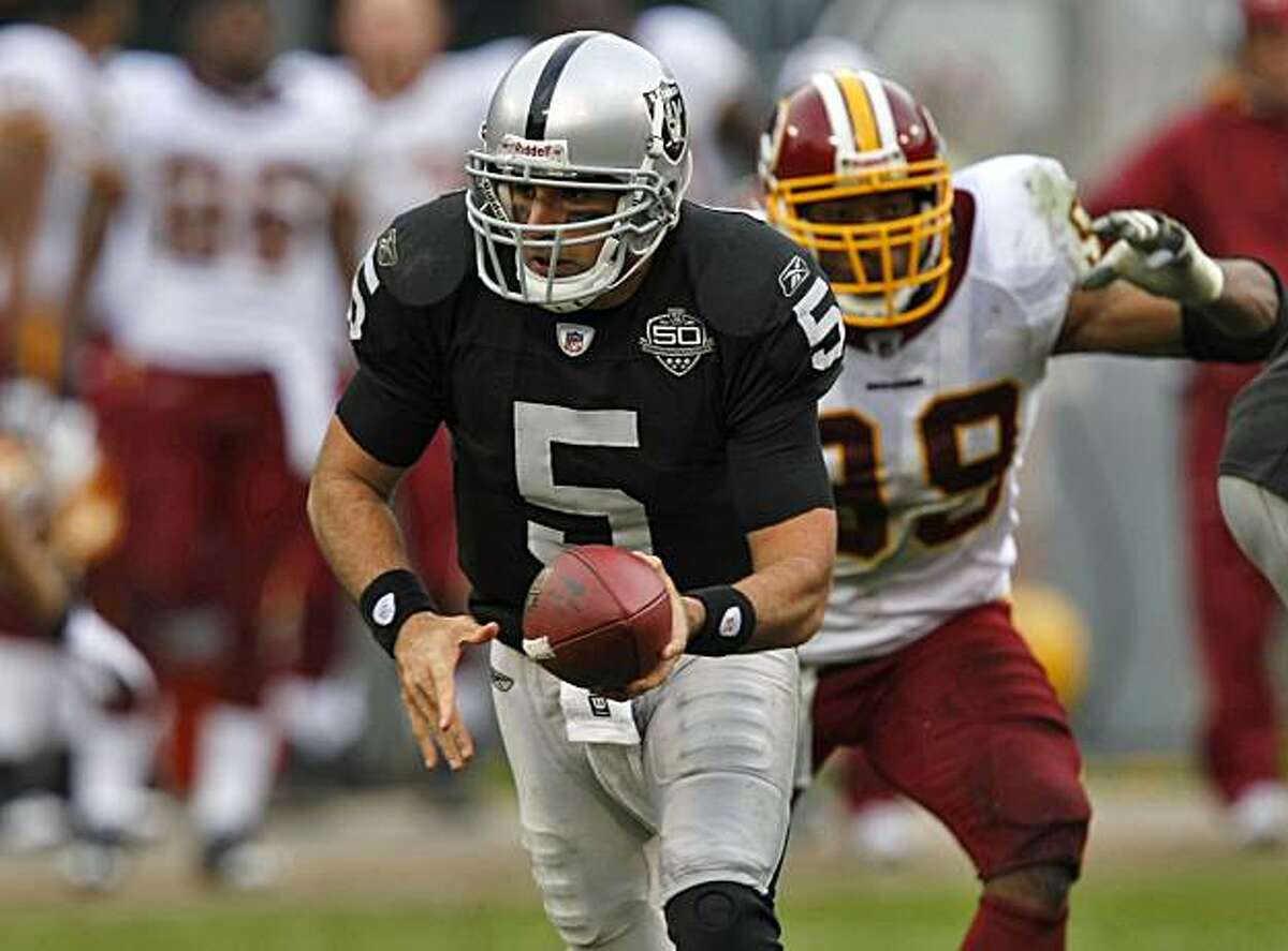 Raiders quarterback Bruce Gradkowski hands of the ball in the first half Sunday in Oakland.