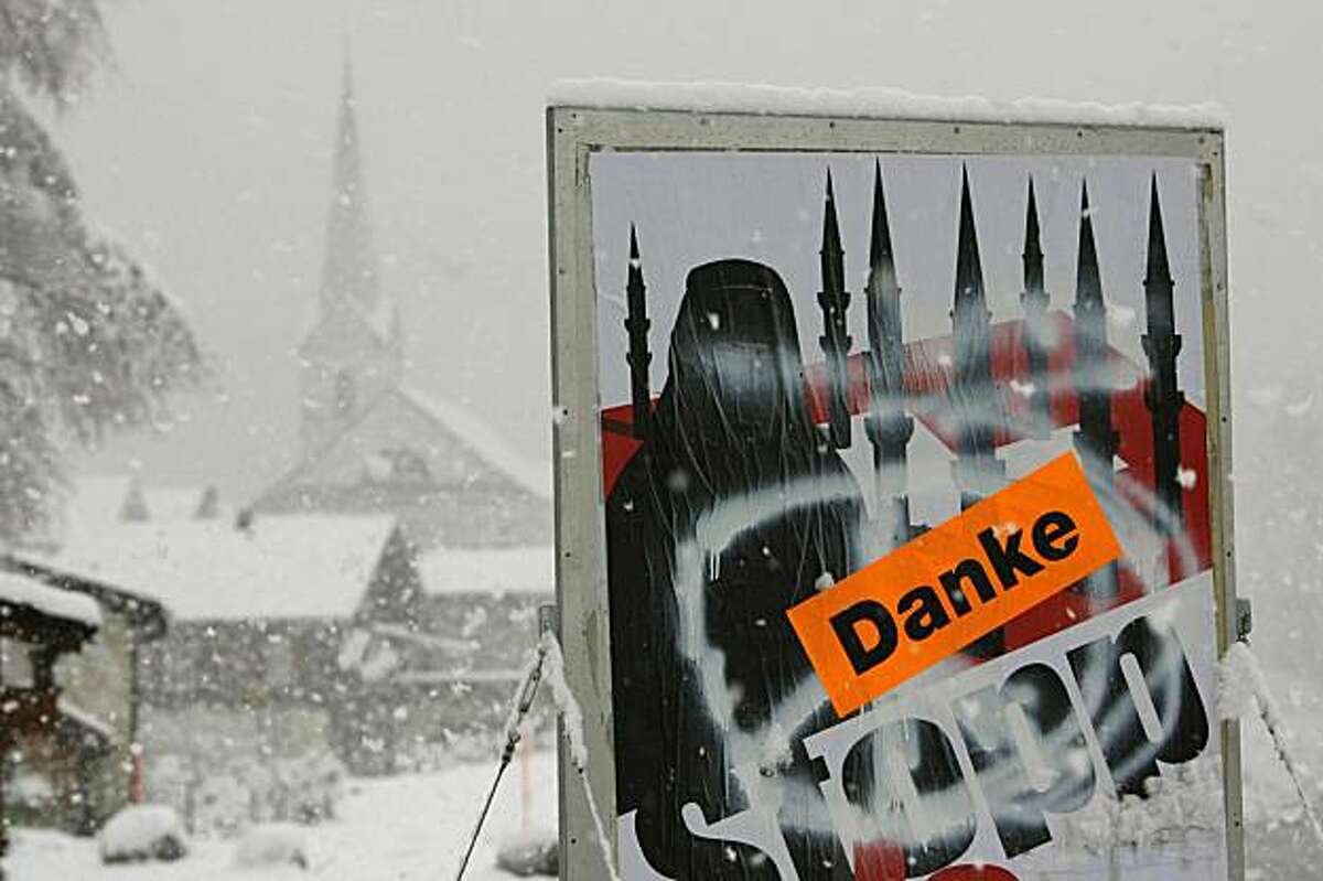 A poster of a conservative initiative promoting the ban of the building of minarets in Switzerland is sprayed with a peace sign and a sticker saying "thank you" in the village of Amsteg in central Switzerland, Monday, Nov. 30, 2009. Swiss voters overwhelmingly approved a constitutional ban on minarets on Sunday, barring construction of the iconic mosque towers in a surprise vote that put Switzerland at the forefront of a European backlash against a growing Muslim population. (AP Photo/Keystone, Urs Flueeler)