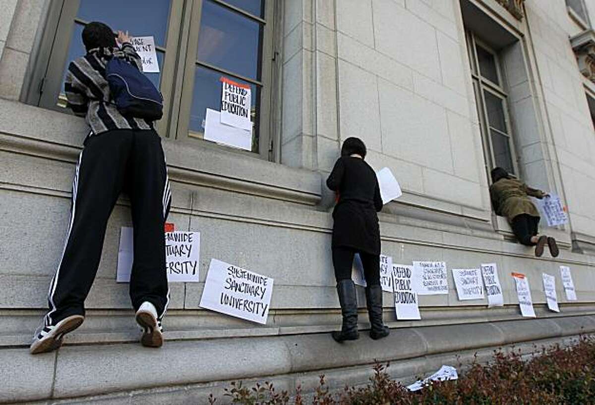 Demontrators climb onto the front of California Hall on the Cal campus to protest fee hikes at the university in Berkeley, Calif., on Wednesday, Dec. 2, 2009.