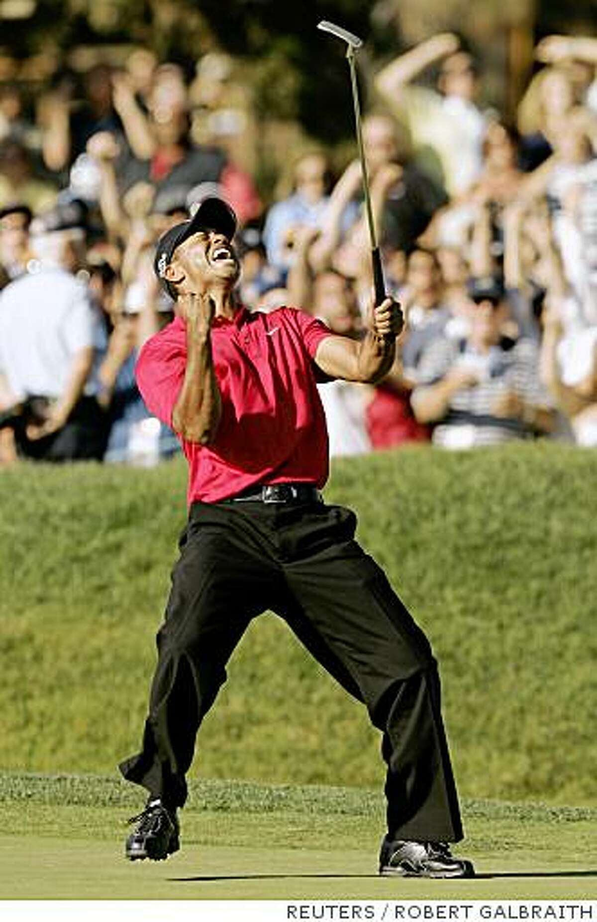 Tiger Woods celebrates sinking a birdie putt on the 18th hole to force a playoff with Rocco Mediate during the fourth round of the U.S. Open golf championship at Torrey Pines in San Diego June 15, 2008. REUTERS/Robert Galbraith (UNITED STATES)