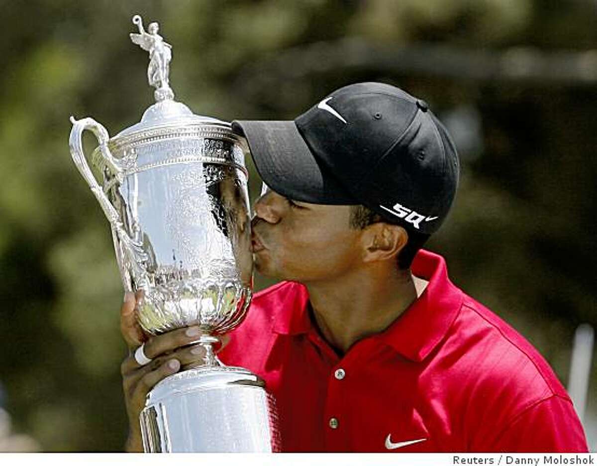 Tiger Woods kisses the U.S. Open trophy after winning a playoff round against Rocco Mediate at Torrey Pines in San Diego June 16, 2008.
