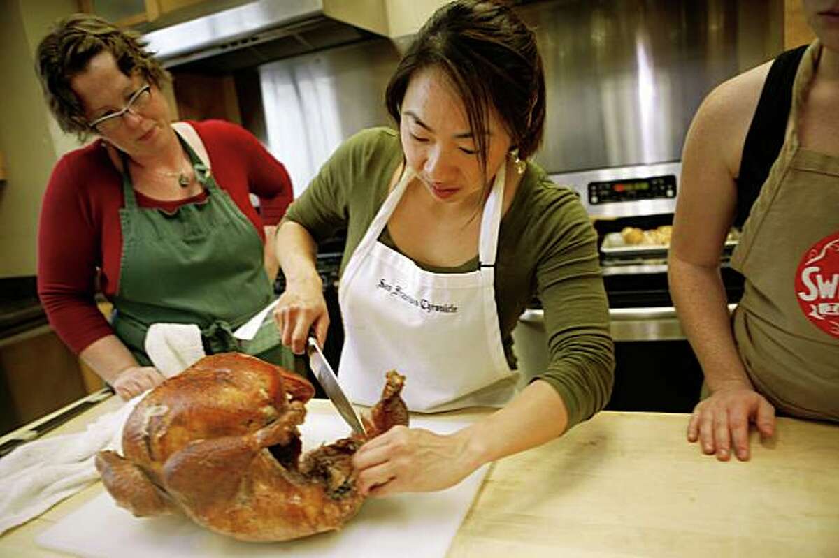 Janny Hu (middle) consults with Sarah Fritsche (left) and Rachael Daylong on how to carve the turkey in the Chronicle test kitchen on Thursday, Nov. 5, 2009 in San Francisco, Calif.