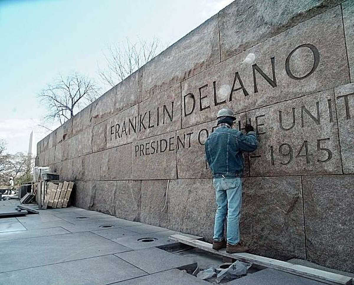 With the Washington Monument in the background, left, master stone cutter John Benson works on the Franklin Delano Roosevelt Memorial in Washington Wednesday, April 9, 1997. The memorial was designed by Lawrence Halprin.