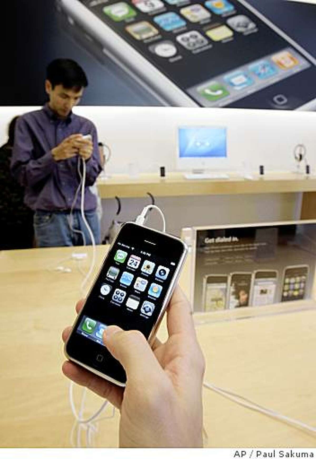 **FILE** In this July 24, 2007 file photo, customers examine Apple iPhones at an Apple store in Palo Alto, Calif.. Apple Inc. says its online stores in the U.S. and U.K. are sold out of the iPhone, a sign supplies are being winnowed ahead of the launch of the device's next generation that will feature faster Internet surfing speeds. (AP Photo/Paul Sakuma)
